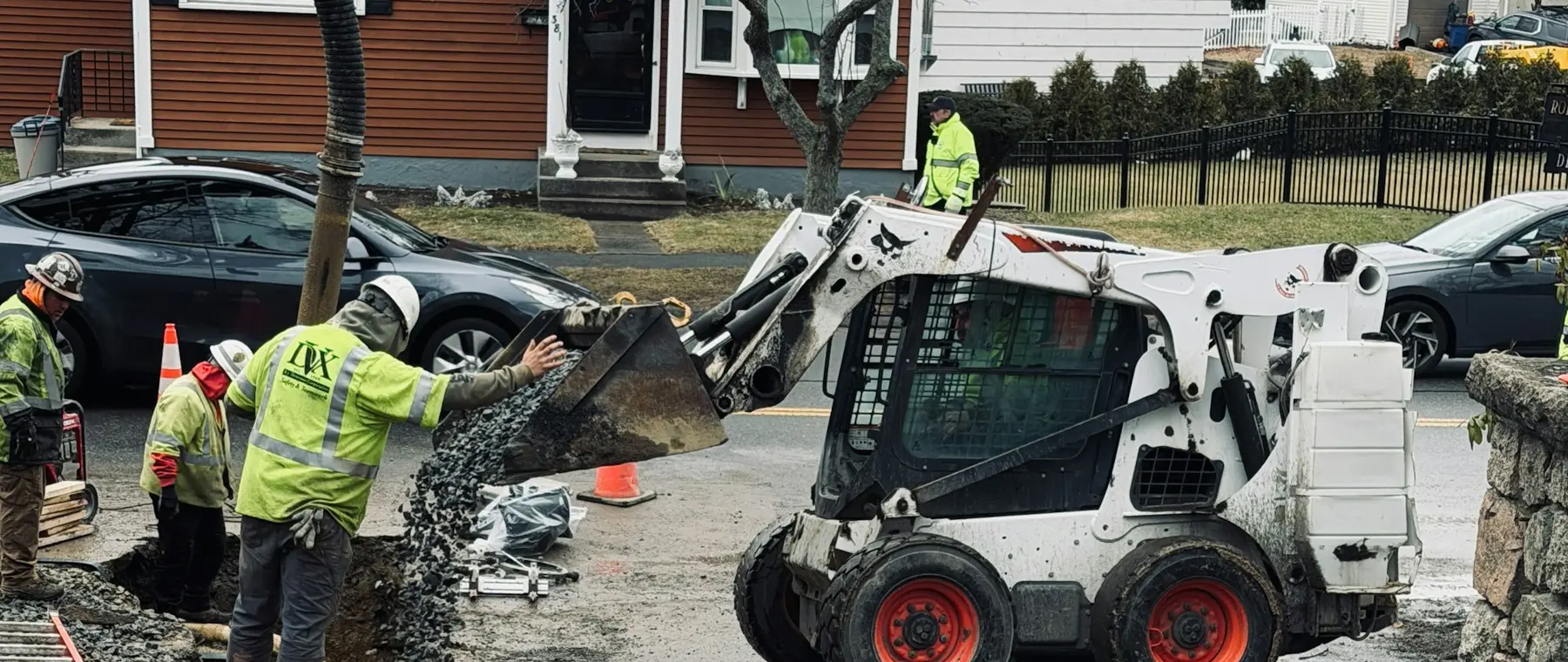Skid-steer and crew working on a residential street