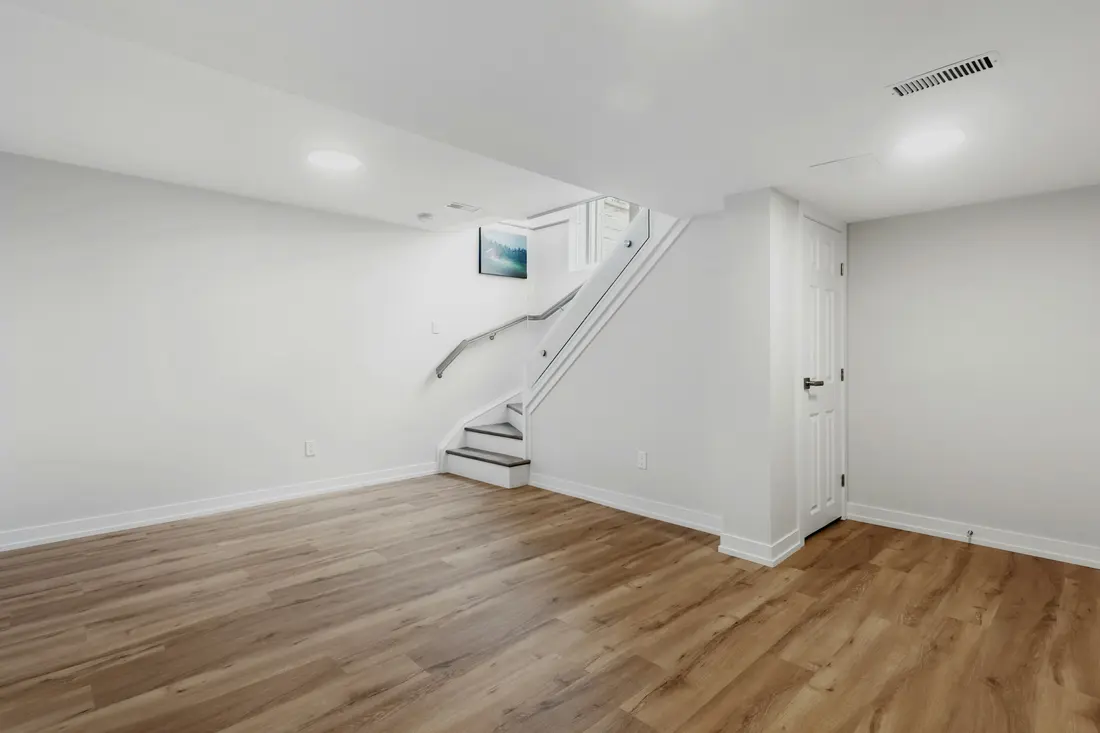 Finished, dry basement room with light walls and new flooring