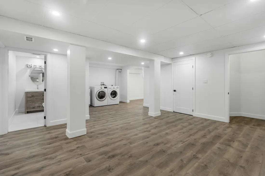 Finished basement laundry area with appliances on a dry, level floor