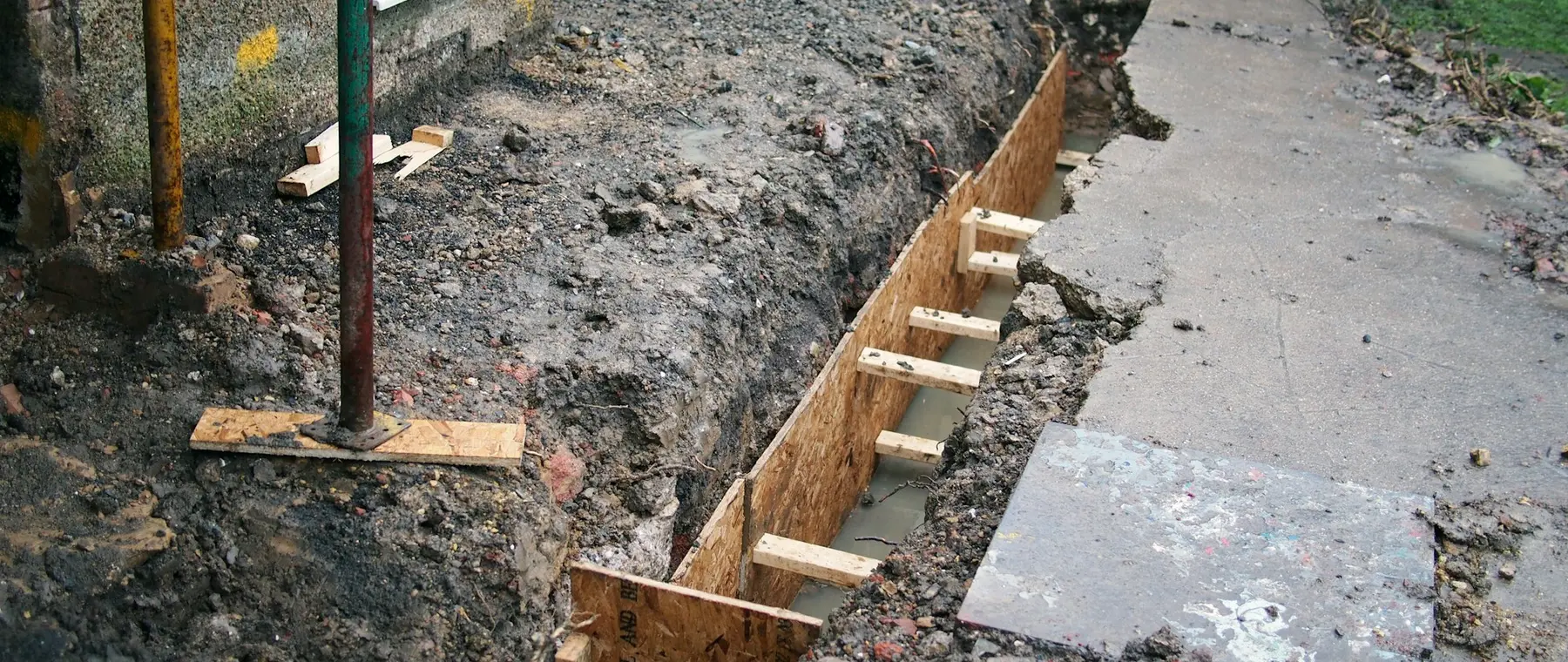 Trench dug along a house foundation with formwork in place