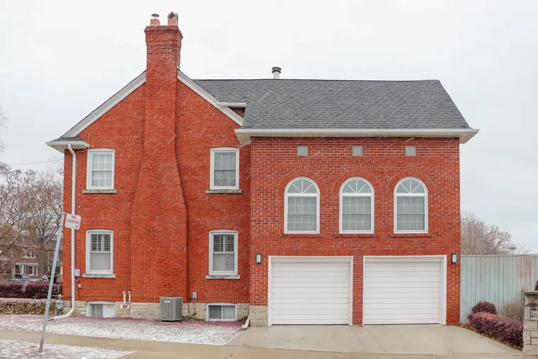 Red brick house with a double garage after a snowfall