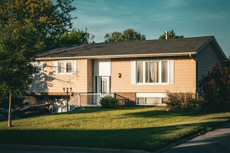 Split-level bungalow with a wide lawn in evening light