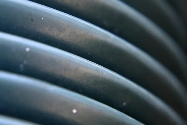 Coiled black perforated drainage pipe ready to be laid